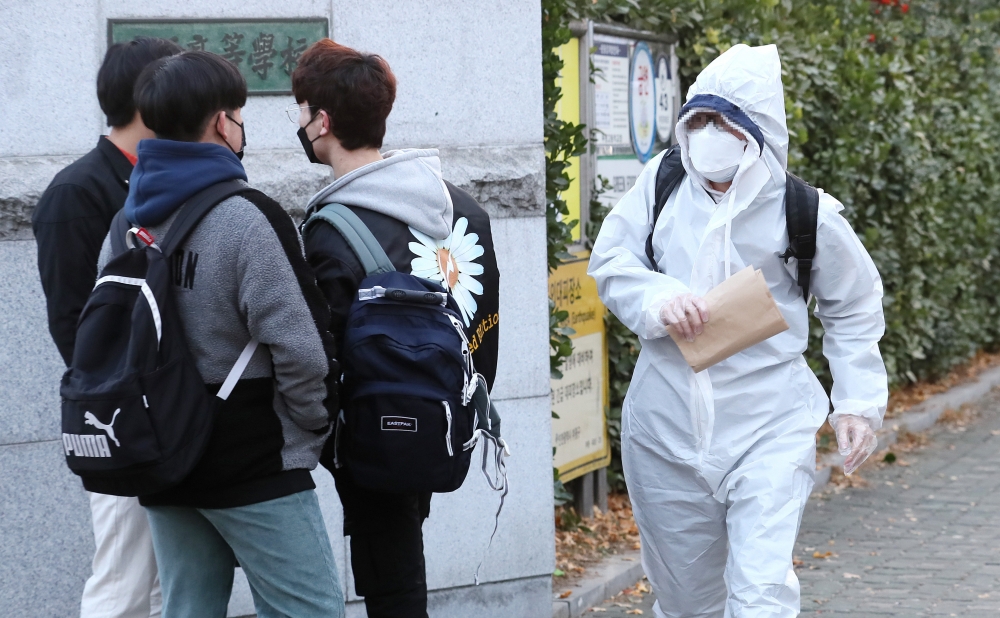 ▲ 2021학년도 대학수학능력시험 수험생이 전신 방호복을 입고 인천 부평고등학교 고사장으로 들어서고 있다.
