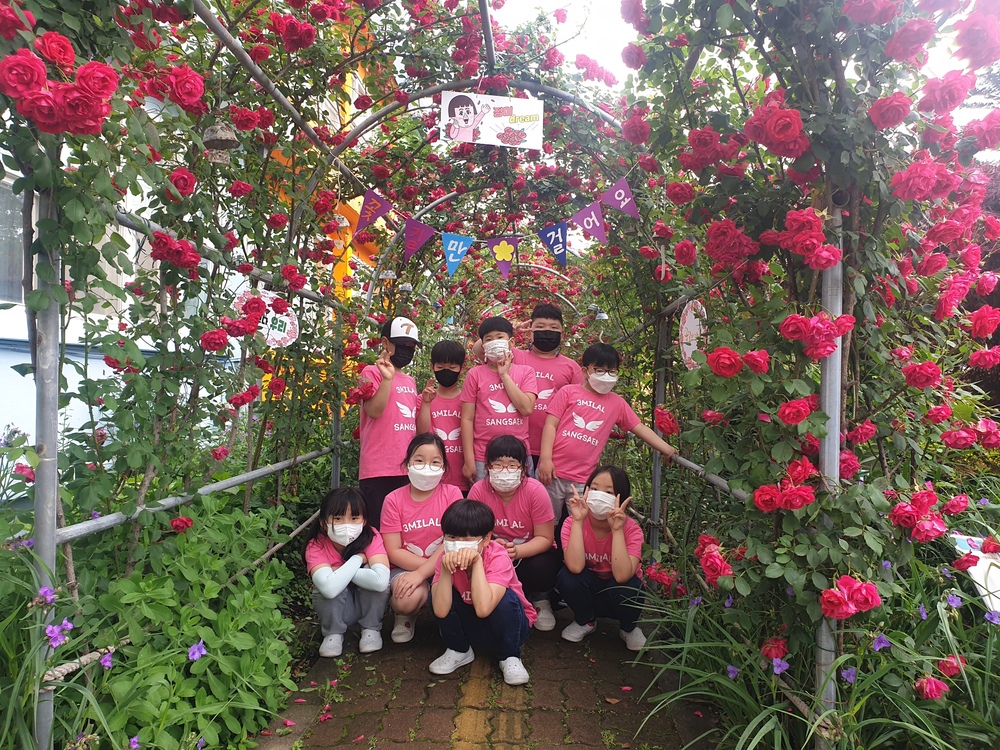 ▲ 매년 5월 '장미의 날' 운영. 장미터널에서 기념촬영을 하고 있는 학생들.