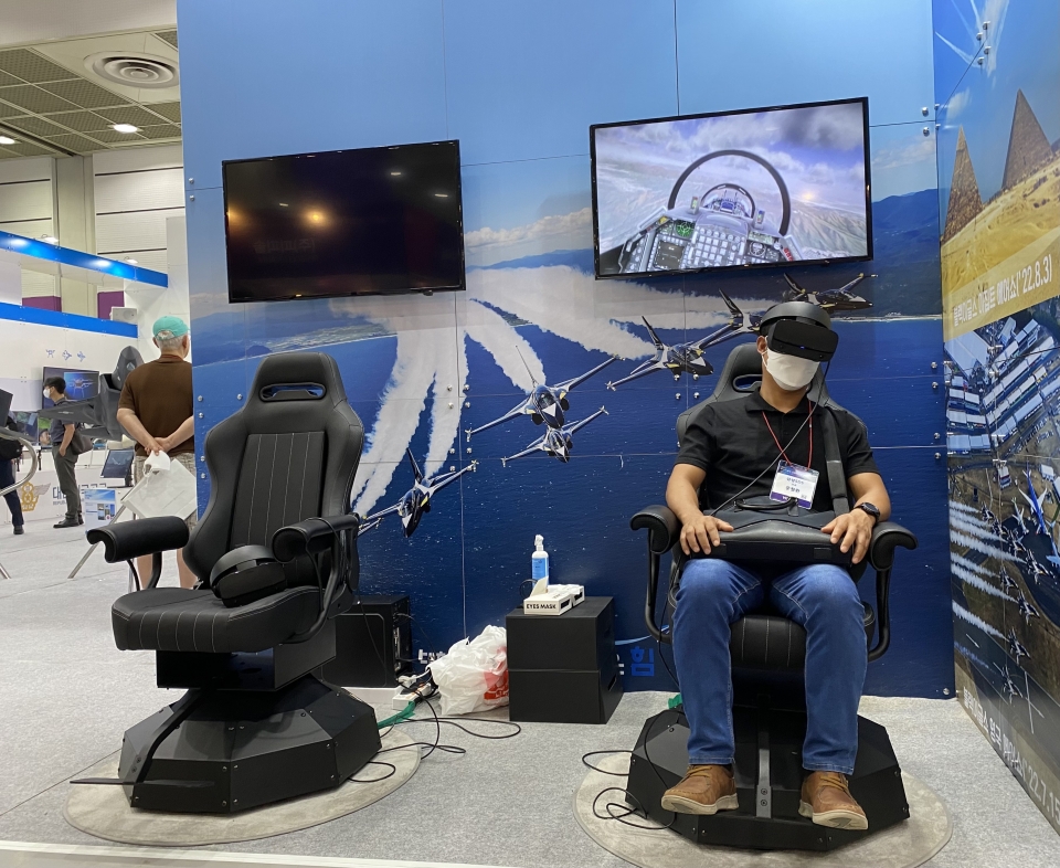▲ 18일 서울 강남구 삼성동 코엑스에서 ‘2022 무인이동체 산업 엑스포’가 열린 가운데 관람객이 대한민국 공군 본부 전시장 앞에 마련된 전투기 블랙이글스 비행 VR체험관을 이용하고 있다. /변성원 수습기자