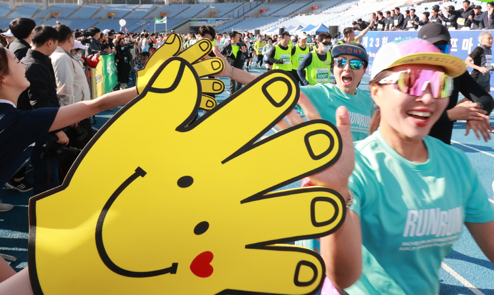 마라톤대회에 참가한 마라토너들이 화이팅을 외치며 문학경기장을 출발하고 있다.<br>