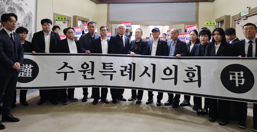 ▲ 국민의힘 수원시의원들이 22일 더불어민주당 의원들을 등진 채 시위를 벌이고 있다.