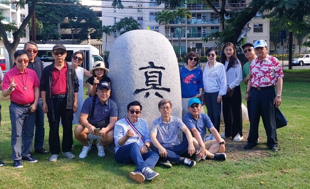 ▲ 인하대총동창회 하와이역사문화탐방단이 호놀룰루시 파와아 인하공원을 방문해 2013년 이민 110주년을 기념해 인하대가 교훈 '진'(眞)을 형상화해 설치한 조형물 앞에서 기념사진을 촬영하고 있다./사진제공=인하대총동창회