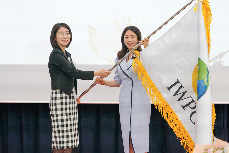 ▲ 세계여성평화그룹(IWPG) 전나영(오른쪽) 신임 대표이사가 지난 1일 서울 스페이스쉐어 서울중부센터에서 열린 대표이사 이·취임식에서 윤현숙 전임 대표이사로부터 단체 깃발을 전달받고 있다. /사진제공=IWPG