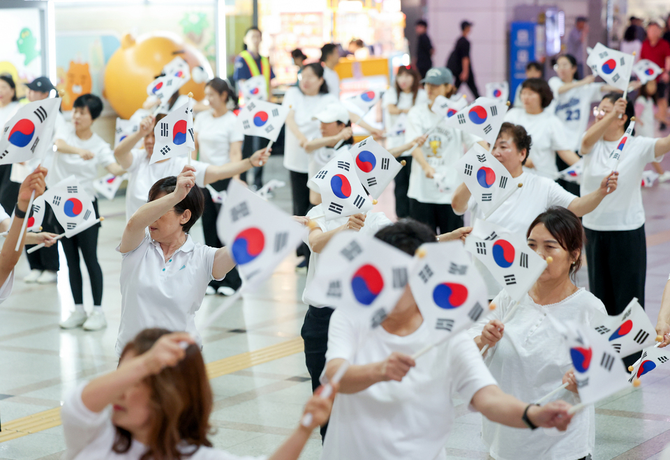 ▲ 제80주년 광복절을 나흘 앞둔 지난 11일 오후 수원시 팔달구 수원역 대합실에서 열린 ‘광복, 그날의 기쁨 재현하다’ 행사에서 권선구 주민자치 댄스 프로그램 수강생들이 태극기를 들고 플래시몹 공연을 하고 있다. /전광현 기자 maggie@incheonilbo.com