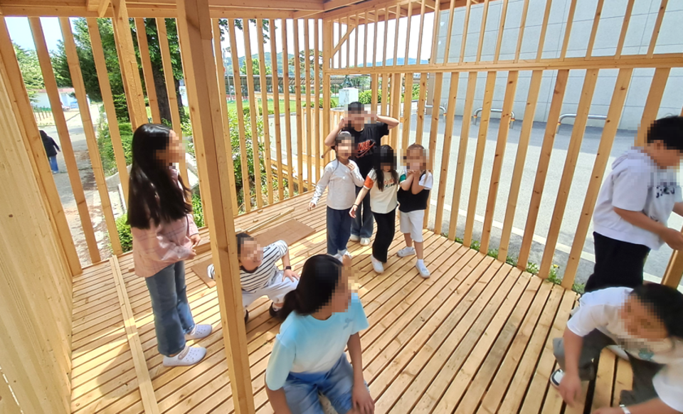 ▲ 조경재 작가가 길상초 학생들과 함께 지은 오두막에서 아이들이 뛰어놀고 있다. /사진제공=인천문화재단