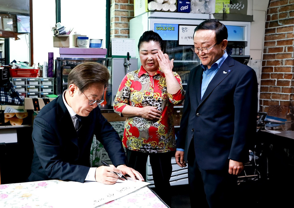 ▲ 지난 6월13일 이재명 대통이 김덕현 연천군수와 함께 청산면을 방문해 경기도 농촌기본소득 시범지역 소상인과 담화을 나누고 방명록을 작성하고 있다. /사진제공=연천군