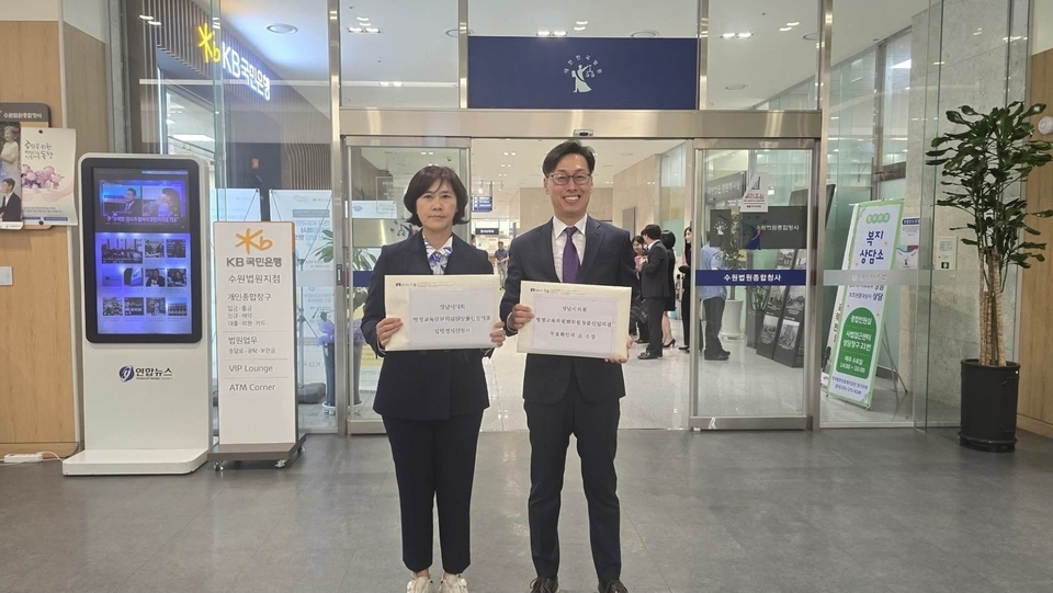 ▲ 성남시시의회 서은경(왼쪽) 의원이 지난 26일 수원지방법원에 행정교육위원장 불신임 효력정지 가처분 신청과 해임 의결 취소의 소 청구 접수에 앞서 변호사와 소장을 들고 법원 민원실 입구에서 사진을 찍고 있다. /사진제공=서은경 의원 페북