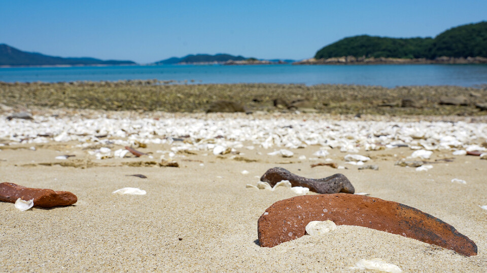▲ 지난 7월 11일 인천 옹진군 덕적면 문갑리 한월리 해변에 모래 사이로 부서진 장독 파편 조각이 흩어져 있다. /조연우 인턴기자 bonun@incheonilbo.com