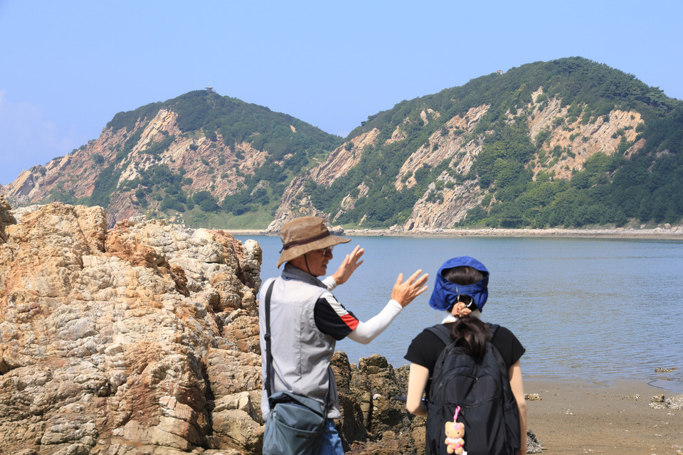 ▲ 조철수 백령·대청 지질공원 해설사가 대청도 농여해변 앞에서 풀등이 형성된 과정에 대해 설명하고 있다. /인천일보