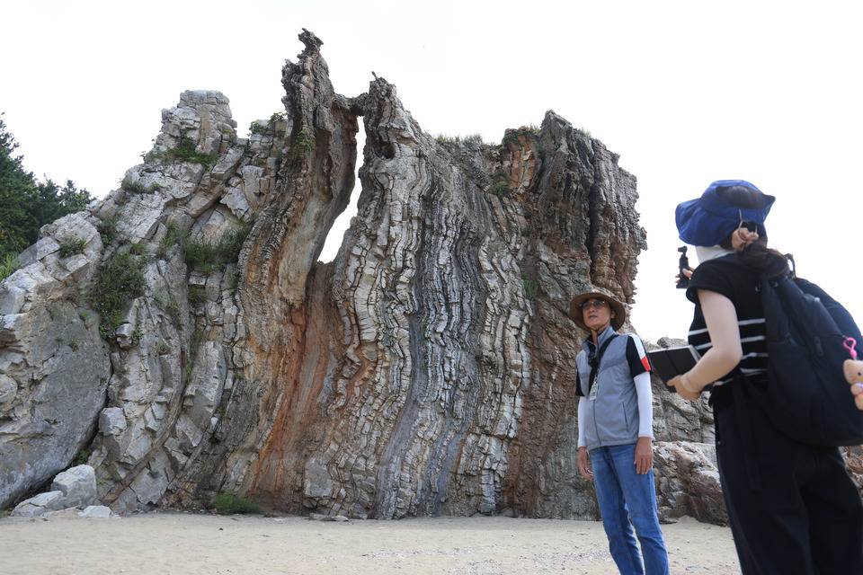 ▲ 약 10억 년 전 바다의 흔적을 고스란히 간직하고 있는 대청도 농여해변 나이테바위. 겹겹이 쌓인 암석 지층이 수직으로 드러나 있다. /인천일보