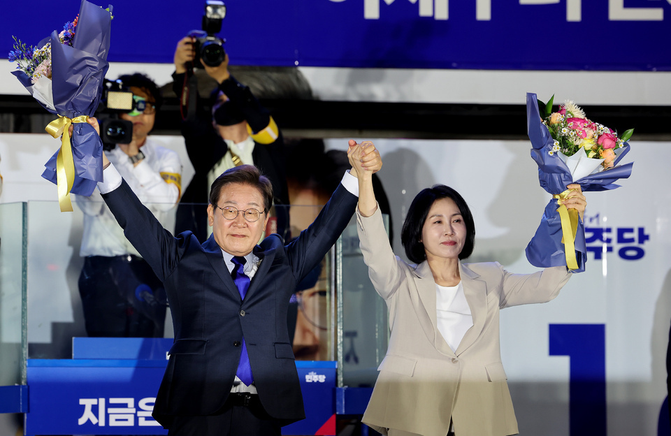 ▲ 4일 서울 영등포구 국회대로에 마련된 개표방송 시청 행사에서 제 21대 대통령 당선이 확실시 된 더불어민주당 이재명 대선 후보와 부인 김혜경 여사가 꽃다발을 들고 시민들을 향해 인사하고 있다. /인천일보DB