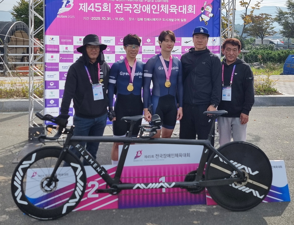 ▲ 제45회 전국장애인체육대회 탠덤사이클 부문 3관왕에 도전하는 김정빈(경기신용보증재단·사진 가운데)과 파일럿 윤중헌(사진 왼쪽 두번째)이 개인도로 독주 19km B(선수부)에서 금메달을 따고 지도자들과 기념촬영을 했다. /사진제공=경기도장애인사이클연맹