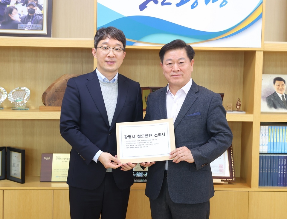 ▲ 박승원 광명시장(사진 오른쪽)이 11일 오후 시장 집무실에서 김기범 경기도 철도항만물류국장(사진 왼쪽)에게 신천~하안~신림선 등 철도 사업의 조속한 추진을 위한 경기도의 적극적인 협조와 지원을 요청하는 건의문을 전달하고 있다. /사진제공=광명시