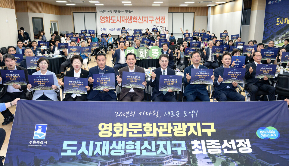 ▲지난 9월 영화동 행정복지센터에서 이재준 수원특례시장(맨 앞줄 왼쪽 다섯 번째)을 비롯한 관계자와 주민들이 영화 문화관광지구 선정을 환영하는 카드를 들어보이고 있다. /사진제공=수원특례시