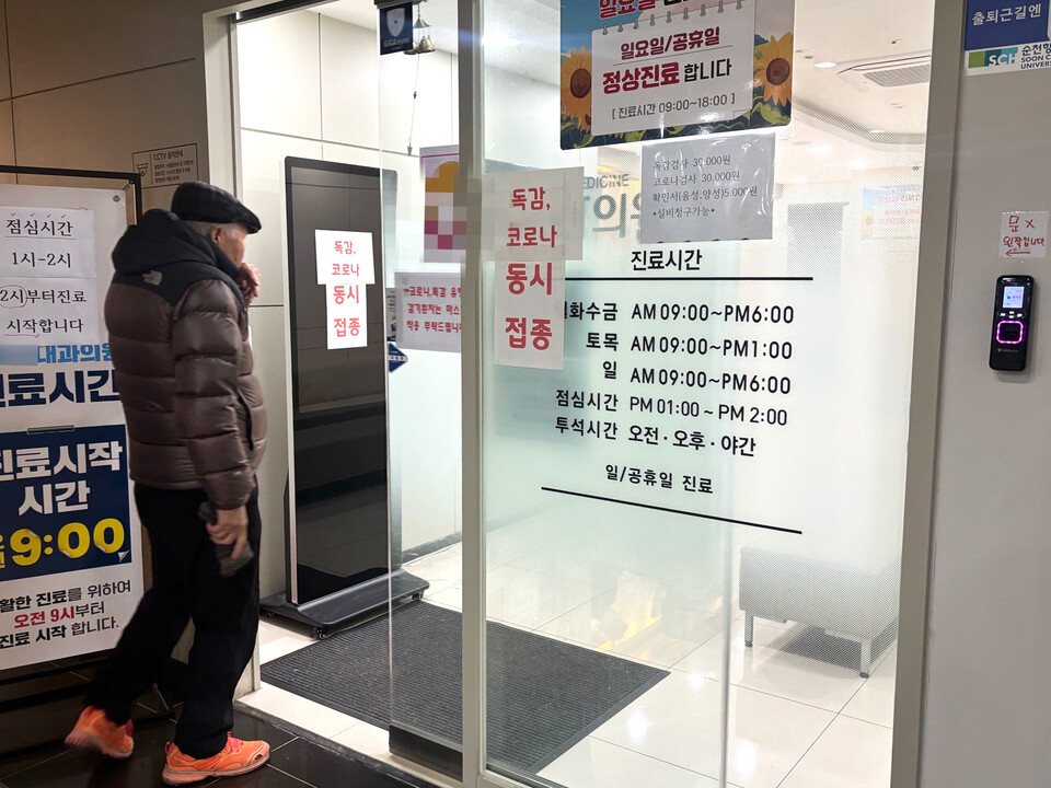 ▲ 18일 인천 계양구 한 내과로 내원객이 들어서고 있다. 병원 입구에는 '독감, 코로나 동시 접종', '마스크 착용' 등을 안내하는 안내문이 붙어 있다.