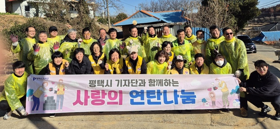 ▲ 평택시기자단과 자원봉사자들이 연탄을 전달하고 기념촬영을 하고 있다. /사진제공=평택시기자단