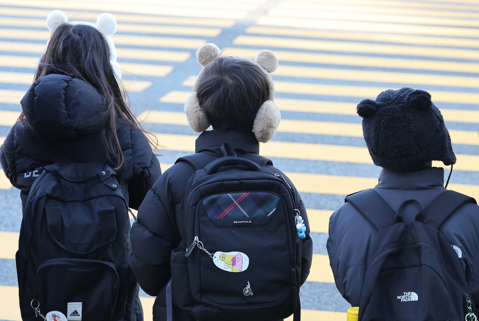 ▲ 지난 18일 경기도 수원시 한 초등학교 앞에서 방한 귀마개를 한 어린이들이 등교하고 있다. /연합뉴스