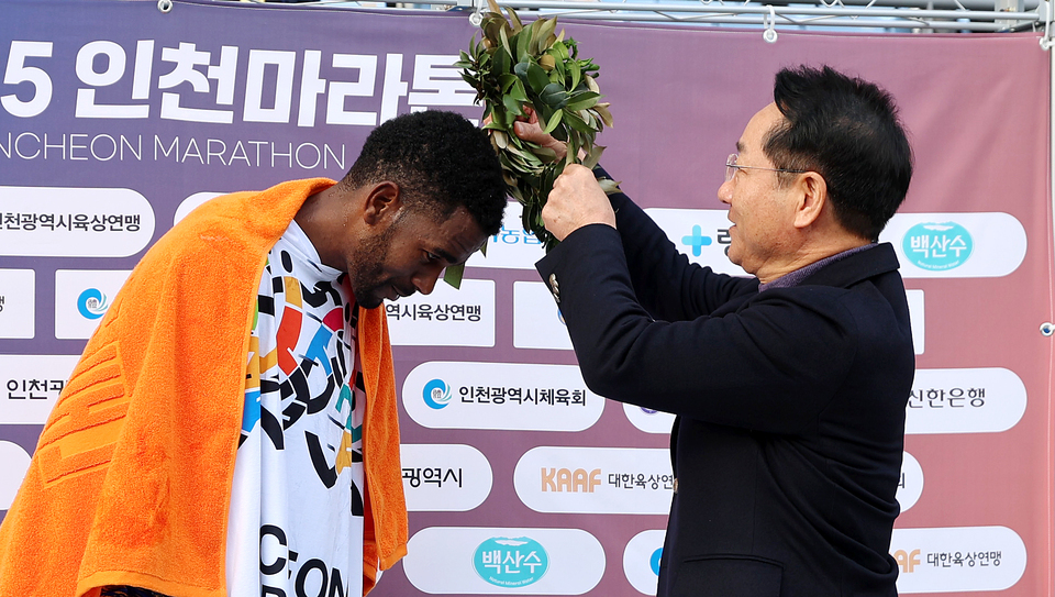 ▲ 23일 인천 미추홀구 문학경기장에서 열린 &#39;2025 인천마라톤&#39;에 참석한 유정복 인천시장이 엘리트 국제부 남자부문 우승 선수에게 월계관을 씌워주고 있다. /이재민 기자 leejm@incheonilbo.com