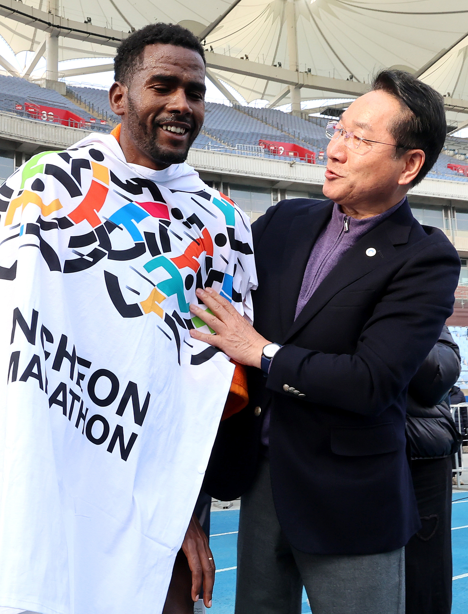 ▲ 23일 인천 미추홀구 문학경기장에서 열린 &#39;2025 인천마라톤&#39;에 참석한 유정복 인천시장이 엘리트 국제부 남자부문 우승 선수에게 타월을 걸어주고 있다. /이재민 기자 leejm@incheonilbo.com