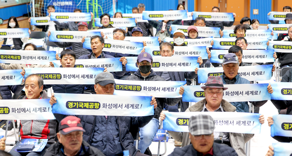 ▲ 22일 오후 화성시 화수초등학교 강당에서 열린 '제1회 화성 서부 발전 세미나'에서 참석자들이 경기국제공항 유치 퍼포먼스를 하고 있다. /전광현 기자 maggie@incheonilbo.com