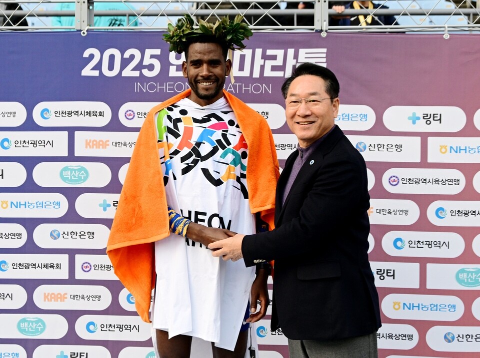 ▲ 유정복(오른쪽) 인천시장이 지난 23일 '2025 인천마라톤' 엘리트 부문 풀코스 남자부 우승자 게르바 베아타 디바바(25·에티오피아) 선수에게 월계관을 씌워 주며 축하 인사를 건네고 있다. /사진제공=인천시