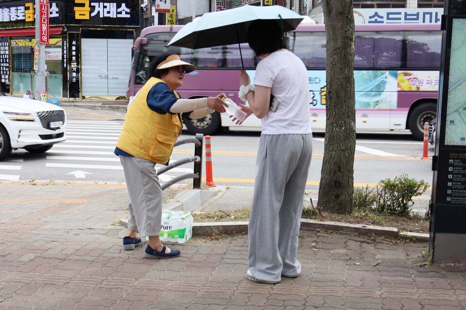 대한적십자사 봉사회 회원이 시민에게 생수를 나눠주는 모습. /사진제공=대한적십자사 경기도지사